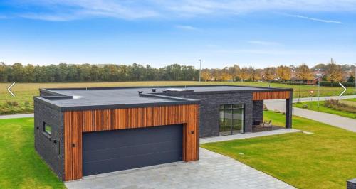 a house with a garage with a roof at Bright, Quiet, Comfortable Room In A Luxury Home in Horsens
