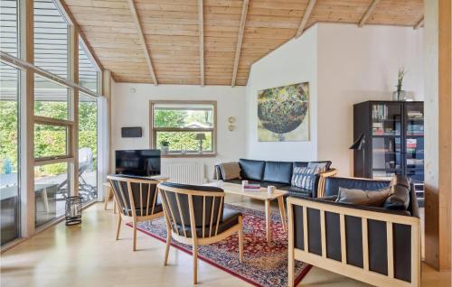 a living room with a couch and a table and chairs at Three-Bedroom Holiday Home In Oksbol in Oksbøl