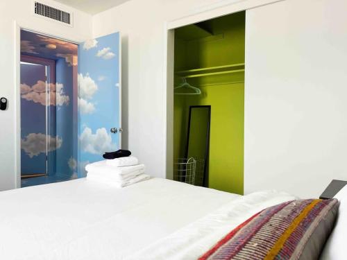 a bedroom with a white bed with clouds painted on the wall at The Tempe Tango POOL and SPA Cute House in Tempe