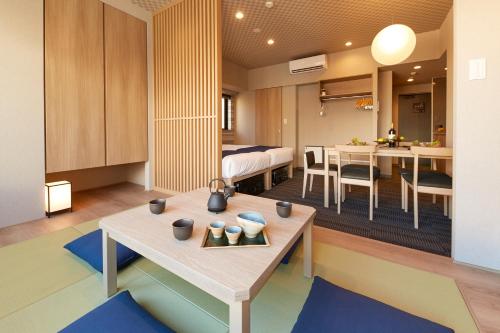 a room with a bed and a dining room with a table at MONday Apart Premium Ginza Shintomicho in Tokyo