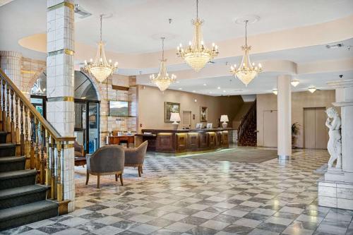 a lobby with a staircase and chandeliers at Chateau Big Bear Boutique Hotel, BW Signature Collection in Big Bear Lake
