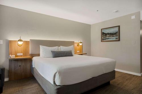 a bedroom with a large white bed and two lamps at Chateau Big Bear Boutique Hotel, BW Signature Collection in Big Bear Lake