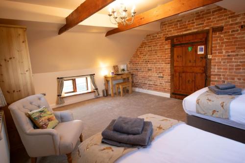 a room with a bed and a chair in a room at The Granary in Martin
