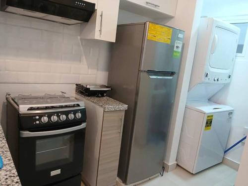 a kitchen with a stainless steel refrigerator and a stove at Pool Feelings Punta Cana in Punta Cana