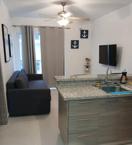 a kitchen with a sink and a couch in a room at Pool Feelings Punta Cana in Punta Cana