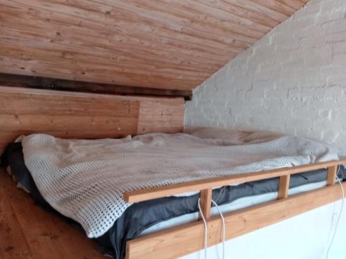 a bed in a room with a wooden ceiling at Windsor cottagestay in Melbourne
