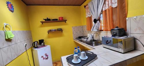 a small kitchen with a sink and a microwave at Alojamientos N&S in Fortuna