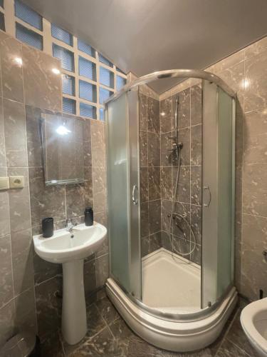 Un baño con ducha, lavabo e inodoro. en Apartment tbilisi central, en Tiflis