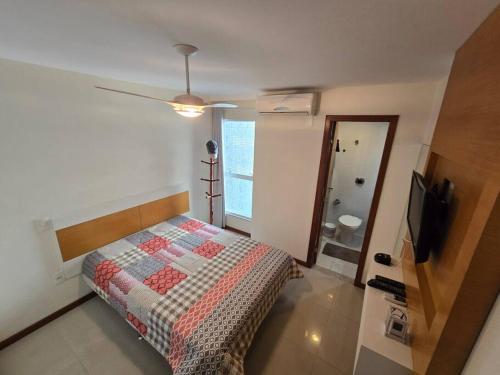 a bedroom with a bed and a television in it at Lindo Apt Beira Mar Guarapari in Guarapari
