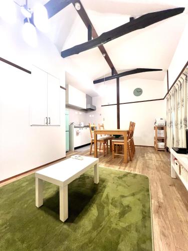 a living room with a table and a kitchen at MIC’s house haneda2 in Tokyo