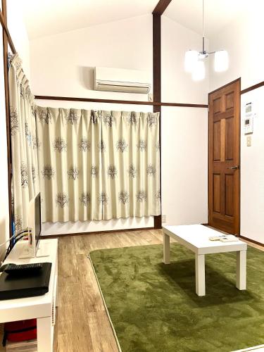 a living room with a curtain and a table at MIC’s house haneda2 in Tokyo