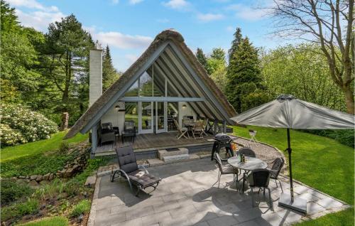 a house with a thatched roof with a patio at 2 Bedroom Nice Home In Aabenraa in Loddenhøj