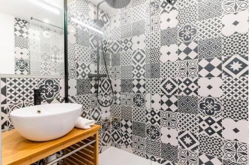 La salle de bains est pourvue d'un lavabo blanc et de carrelage noir et blanc. dans l'établissement La Tanière de la Loire 3Chambres, à Nantes