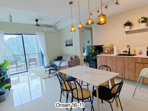 a kitchen and living room with a table and chairs at Sunway Onsen Signature Themepark Suites with Hotspring by IWH Suites in Ipoh