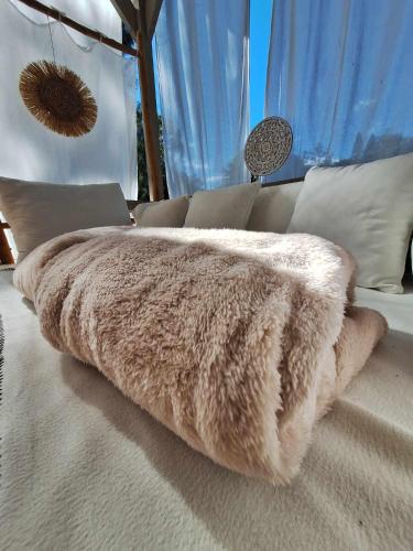 a faux fur blanket sitting on top of a bed at Love Room Les sens'même in Bouloupari