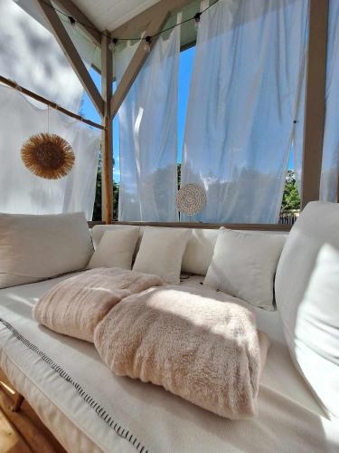 a white couch with two pillows on top of it at Love Room Les sens'même in Bouloupari