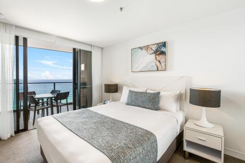 a bedroom with a bed and a view of the ocean at Rhapsody Resort - Official in Gold Coast