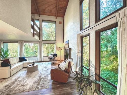 a living room with large windows and a couch at Uplake Forest Retreat in Kenmore
