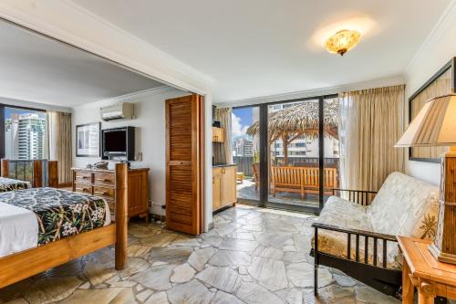 a hotel room with a bed and a balcony at Castle Bamboo Waikīkī Hotel in Honolulu