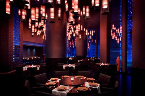 a dining room with tables and chairs and chandeliers at JW Marriott Marquis Hotel Dubai in Dubai