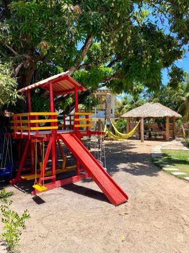 a playground with a red slide in a park at Village do Sossego in São José da Coroa Grande