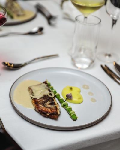 a white plate with a piece of food on a table at Q's Boutique Stay in Standerton