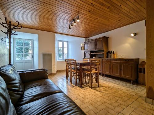 un salon avec un canapé et une cuisine avec une table dans l'établissement Gîte familial en Haute-Loire avec terrain clos, à proximité de l'Ardèche et des stations de ski - FR-1-582-236, à Freycenet-la-Tour