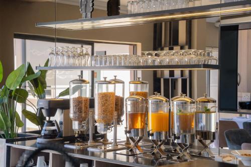 a bar with glasses and bottles of orange juice at Q's Boutique Stay in Standerton