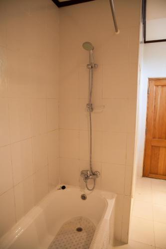a bath tub with a shower in a bathroom at Gorillas Lake Kivu Hotel in Gisenyi