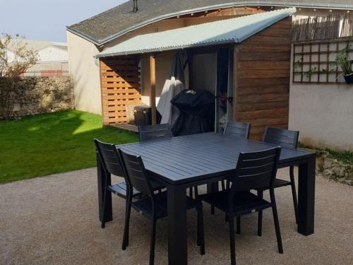 a black table and chairs in front of a shed at Charmant gîte au cœur du Val de Loire, proche châteaux, Orléans, avec jardin et équipements complets - FR-1-590-258 in Sigloy