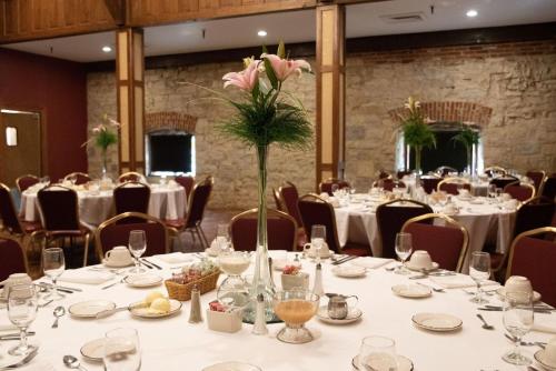 a banquet room with tables and chairs with flowers at Holiday Inn At Six Flags Saint Louis by IHG in Eureka