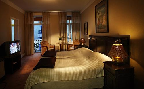 a bedroom with a large bed and a television at Hotel Lilton in Ängelholm