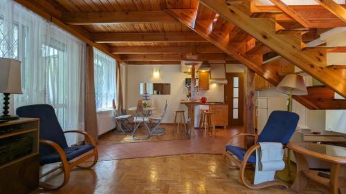 a living room with wooden ceilings and blue chairs at Zofiowka Relax Retreat in Zofiówka