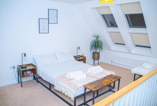a bedroom with a bed and a table and windows at Entire Home in Manchester in Manchester