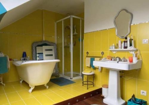 La salle de bains jaune est pourvue d'une baignoire et d'un lavabo. dans l'établissement urban jungle - T2 - centre Tourcoing, à Tourcoing
