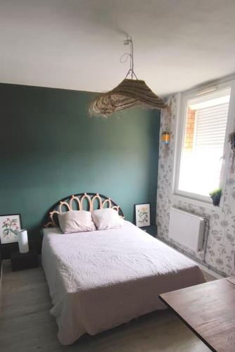 une chambre avec un lit et un mur végétal dans l'établissement urban jungle - T2 - centre Tourcoing, à Tourcoing