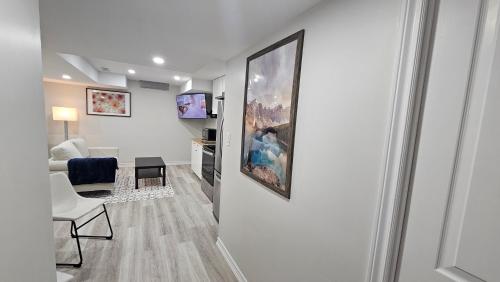 a living room with a couch and a chair and a painting on the wall at Garden Ave Home 1mins to HWY 403 in Brantford