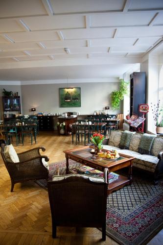 a living room with couches and a table and chairs at Hotel Lilton in Ängelholm