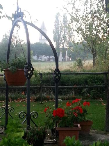 a garden with red flowers and a swing at Relais Ristorante Sanfront in Ponzone