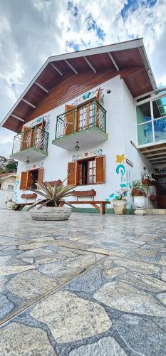 a large white building with two balconies on it at Pousada D' Paula in Campos do Jordão