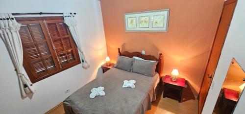 a bedroom with a bed with two towels on it at Pousada D' Paula in Campos do Jordão