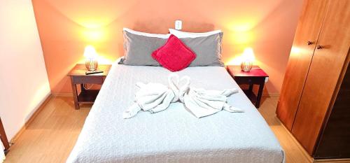 a bed with two towels on it with two lamps at Pousada D' Paula in Campos do Jordão