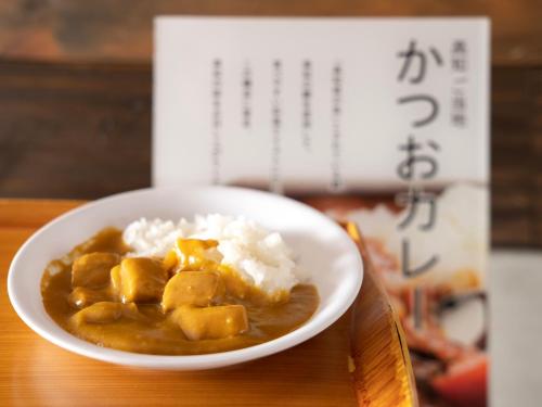 a bowl of stew with rice and a book at Super Hotel Kochi in Kochi