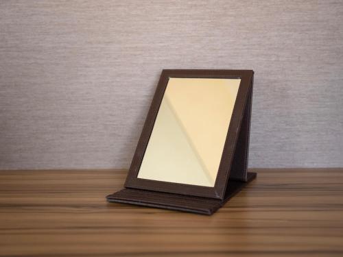 a mirror sitting on top of a wooden table at Super Hotel Kochi in Kochi