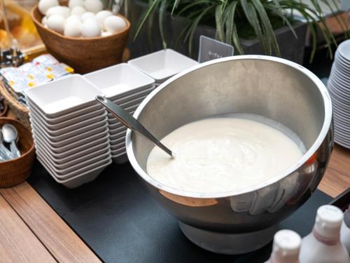 a bowl of milk sitting on a table with eggs at Super Hotel Kochi in Kochi