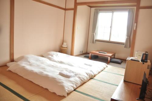 Postel nebo postele na pokoji v ubytování 三笠の宿 Mikasanoyado