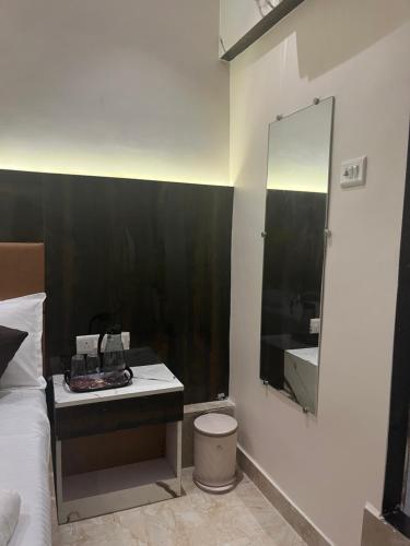 ムンバイにあるHotel Powai Palaceのベッドと洗面台と鏡のある寝室