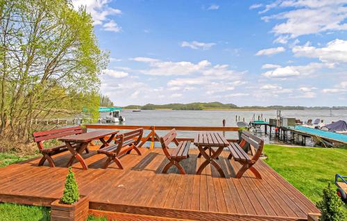 a picnic table and benches on a deck next to the water at Ferienwohnung Südmüritz in Vipperow