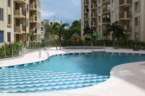 a swimming pool in front of some apartment buildings at El descanso que mereces,es aquí. in Girardot