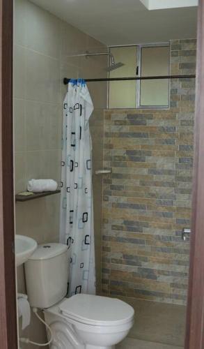 a bathroom with a toilet and a shower curtain at El descanso que mereces,es aquí. in Girardot